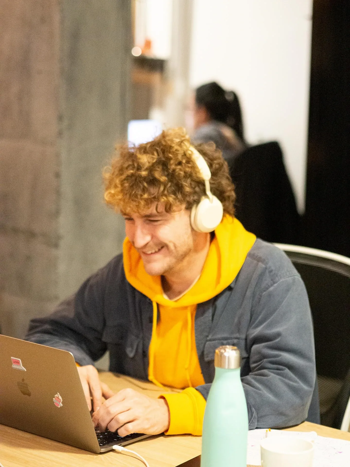 Joven sonriendo mientras trabaja en el coworking de Neurona Center