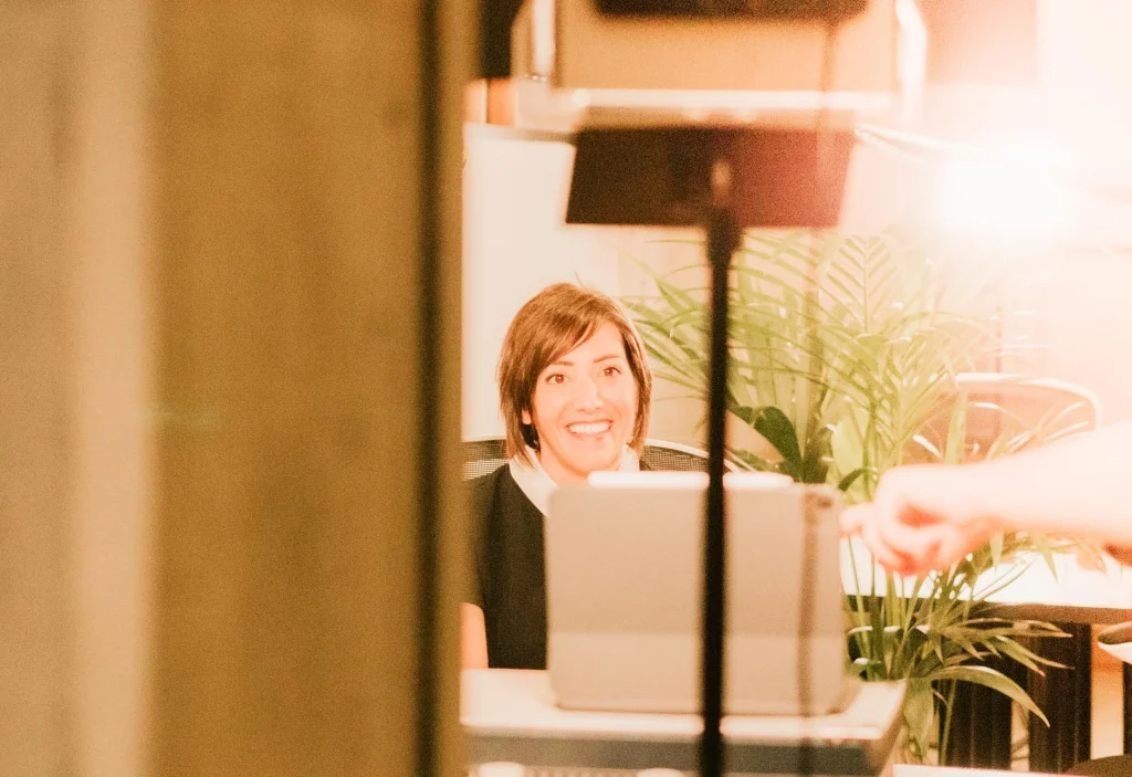 Mujer sonriendo en escritorio Mujer sonriendo mientras trabaja en un escritorio con portátil